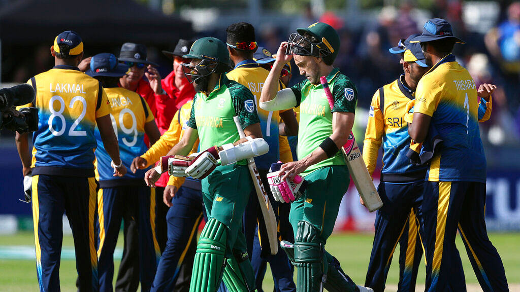 Hashim Amla, left, with his captain Faf du Plessis leave the field at the end of the Cricket World Cup match.
