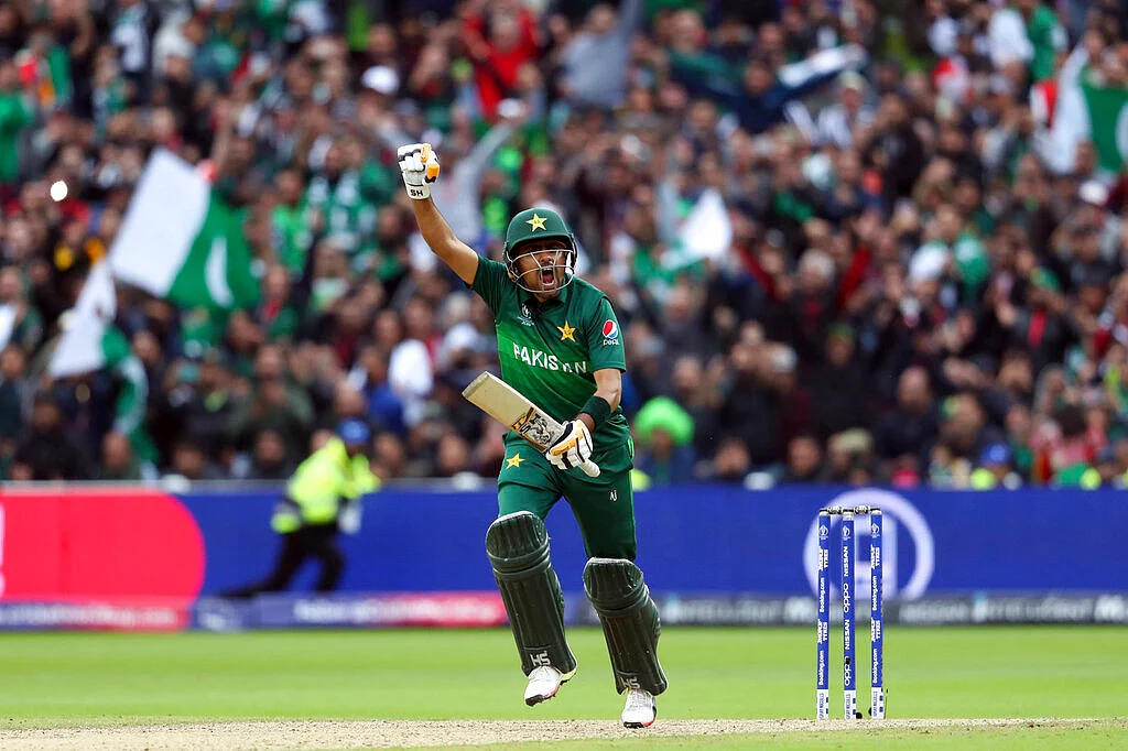 Babar Azam raises his fist to celebrate scoring a century.