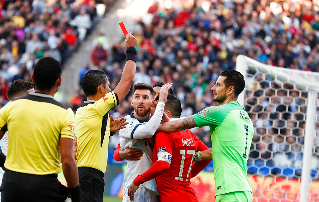 Argentina's Lionel Messi, center left, and Chile's Gary Medel, center right, scuffle as referee Mario Diaz, from Paraguay shows the red card to both of them during the Copa America third-place soccer match