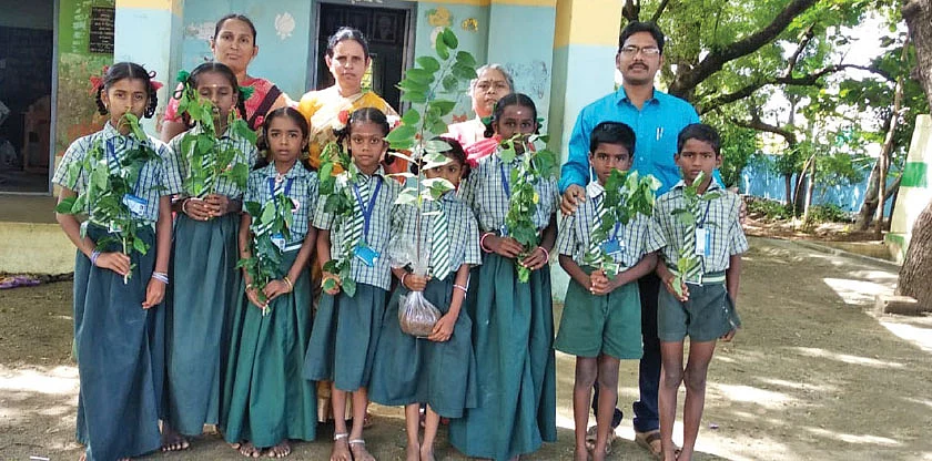 மரக்கன்றுகளுடன் மாணவர்கள்