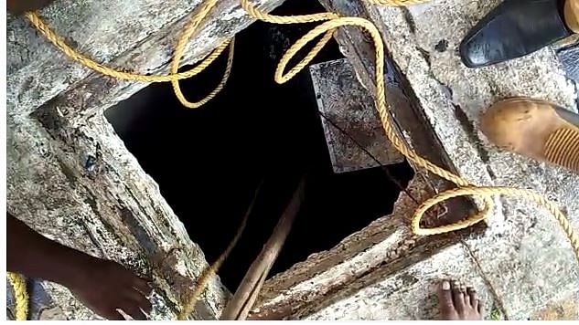 கழிவுநீர் தொட்டிக்குள் விழுந்தவரை மீட்கும் தீயணைப்பு வீரர்