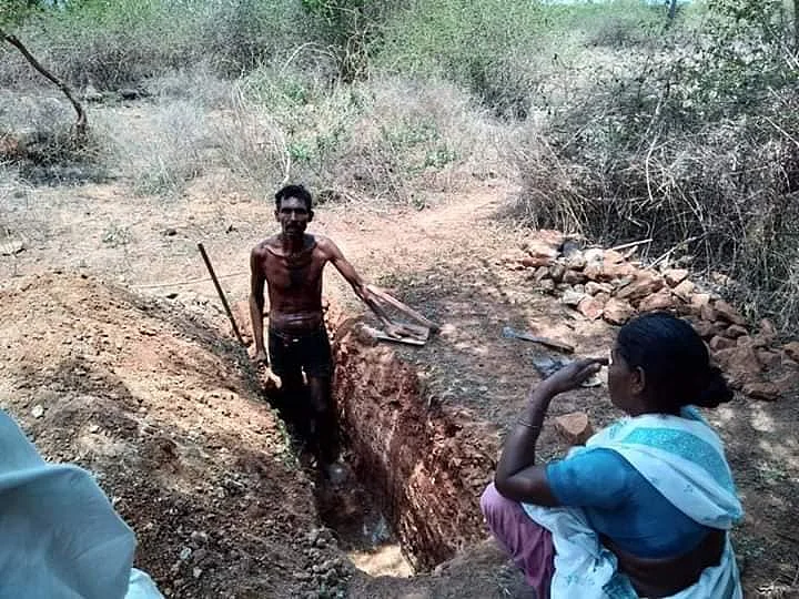 மனைவியுடன் சவக்குழி தோண்டும் ஊராட்சித் தலைவர் முருகேசன்