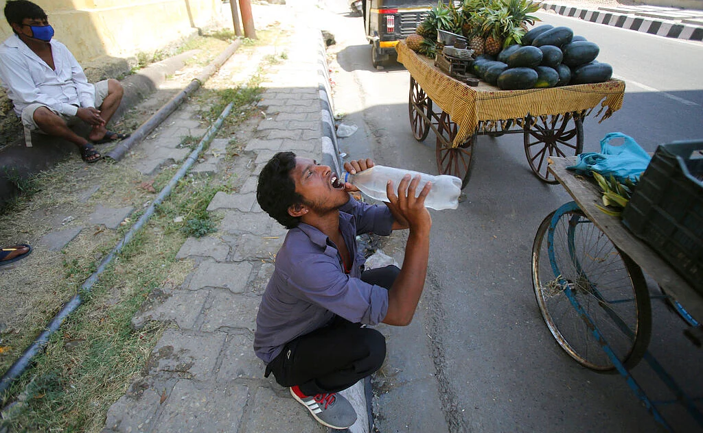 A vendor drinks water on a summer day in Jammu, India.