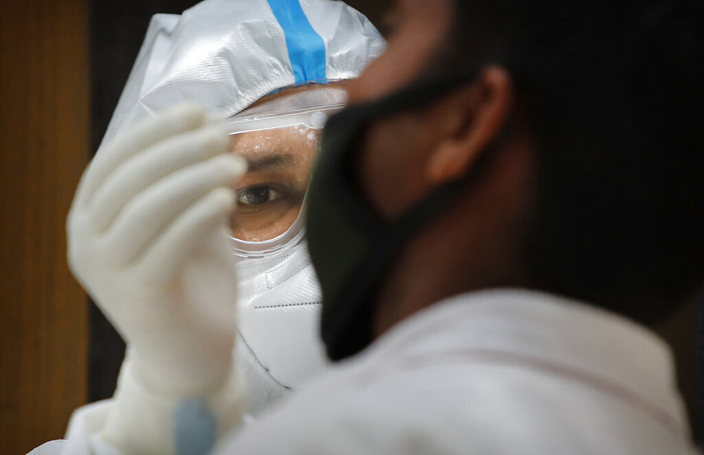 A health worker takes a nasal swab to test for COVID-19