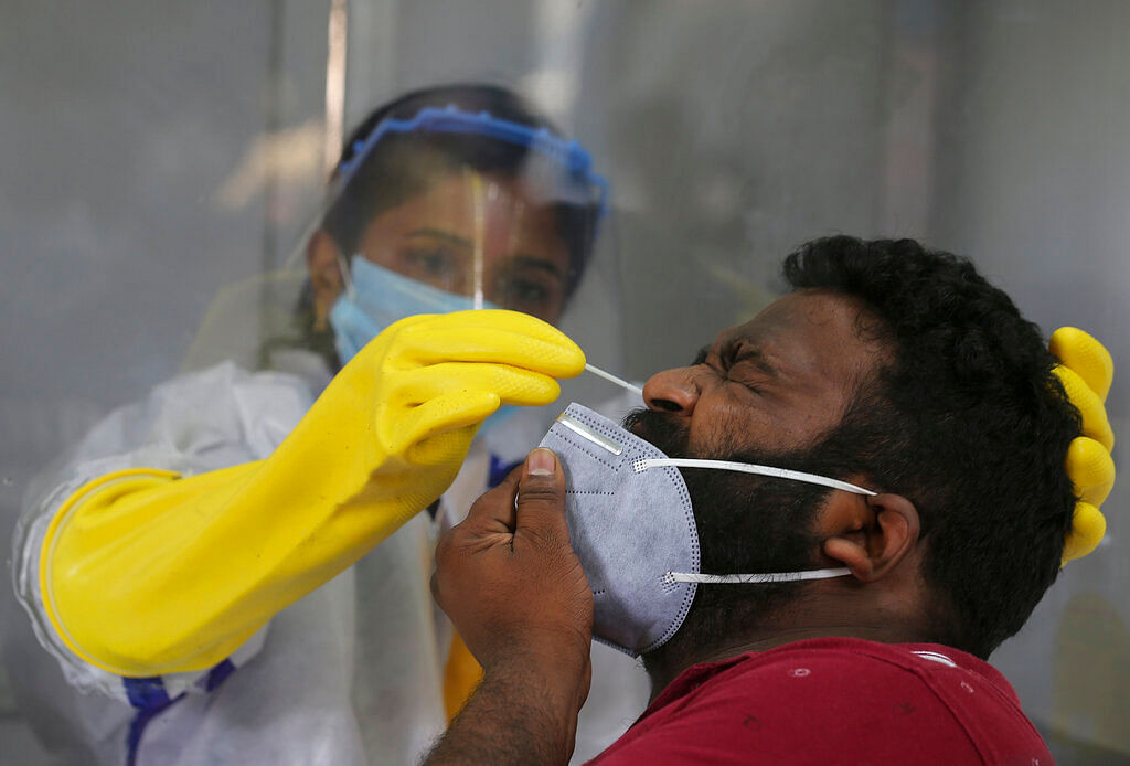 A health worker takes a nasal swab sample to test for COVID-19 in Hyderabad, India