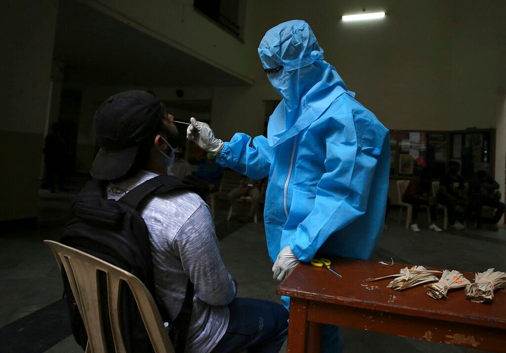 A health worker takes a nasal swab sample