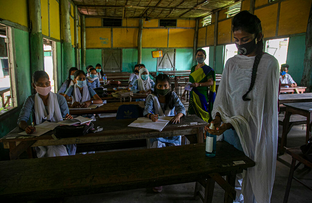 A student uses hand sanitizer in a class as schools in north-eastern Assam state reopen after being closed for months due to the coronavirus pandemic in Gauhati, India