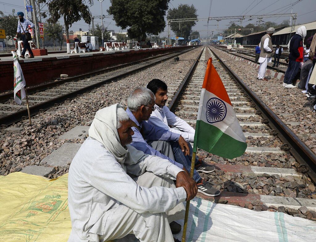 Farmers block a railway track during a protest denouncing three farm laws approved by Parliament in September