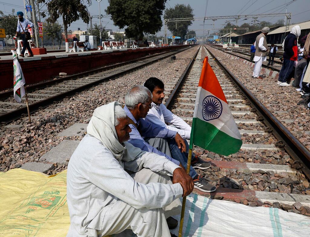 Farmers block a railway track during a protest denouncing three farm laws approved by Parliament in September