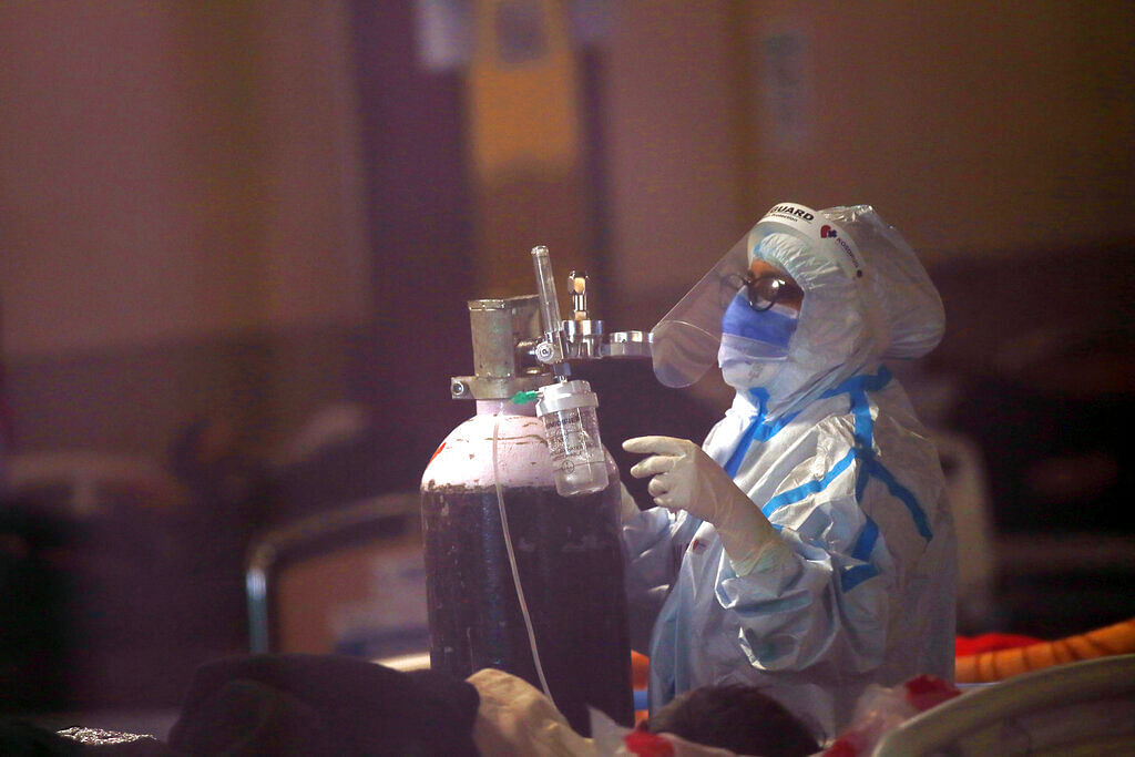 A health worker fixes an oxygen cylinder