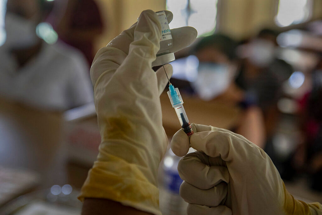 A health worker prepares to administer a dose of the covaxin COVID-19 vaccine