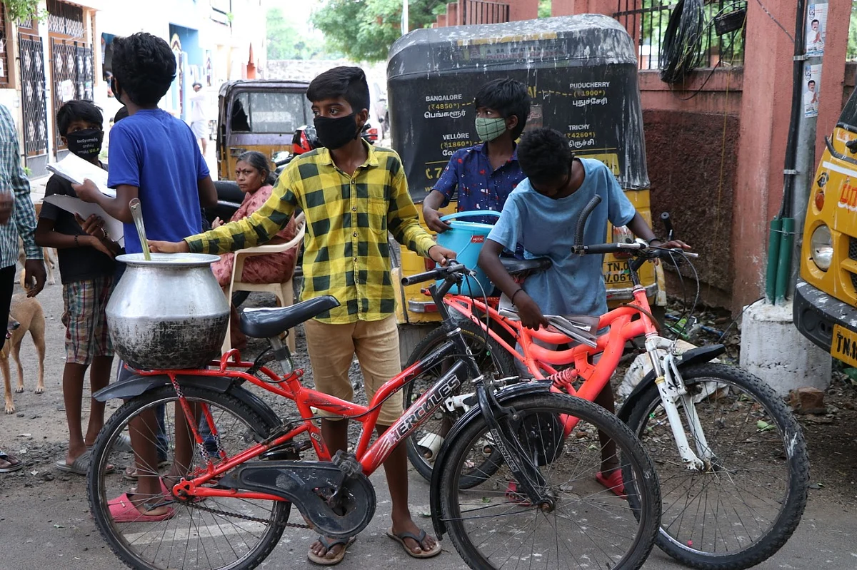 நாய்களுக்கு உணவளிக்கும் சிறுவர்கள்