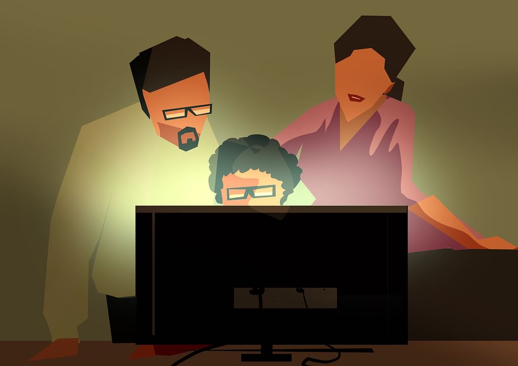 Pavan, Kavya, and Professor Murugan huddled up in front of a computer to discuss programming