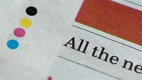 Four Coloured dots printed at the bottom of a newspaper