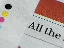 Four Coloured dots printed at the bottom of a newspaper