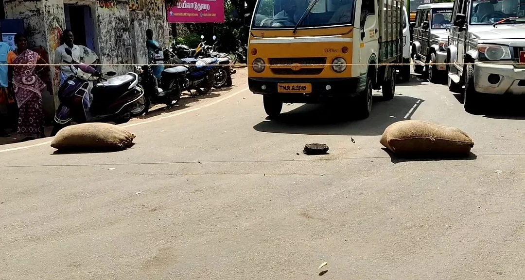 சாலையில் வீசப்பட்ட நெல் மூட்டைகள்