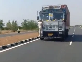 வைரல் வீடியோ: சுங்கக் கட்டணம் கேட்டு லாரி பம்பரில் ஏறிய ஊழியர்.. அப்படியே 10 கி.மீ இயக்கிய ஓட்டுநர்!