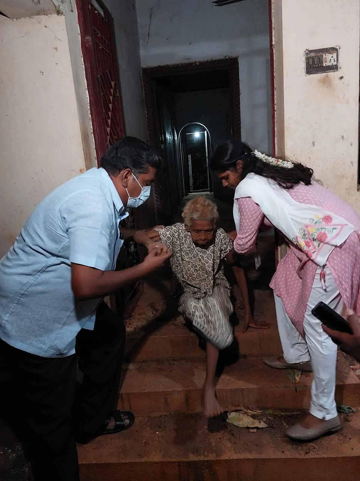 முதிய தாயை மீட்கும் அலுவலர்கள்