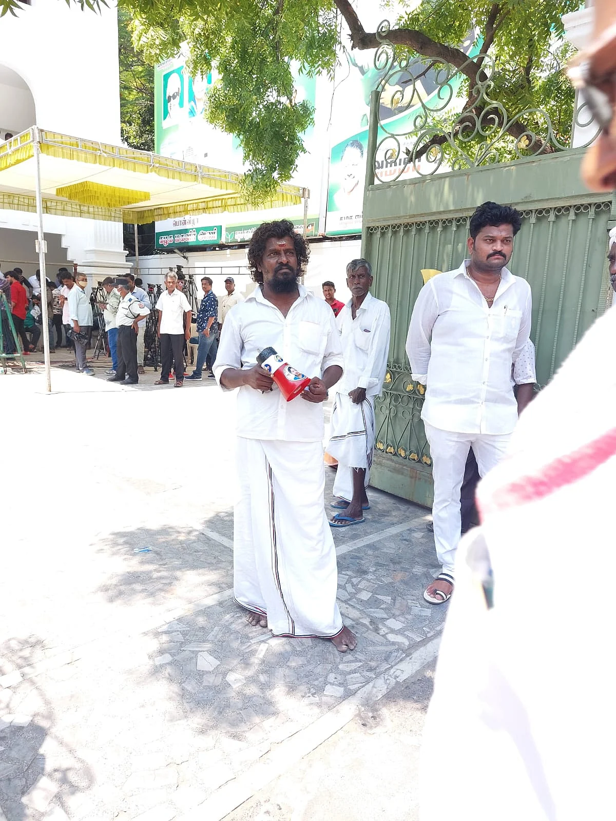 ஒலிபெருக்கியில் பாடல் இசைக்கும் தொண்டர்