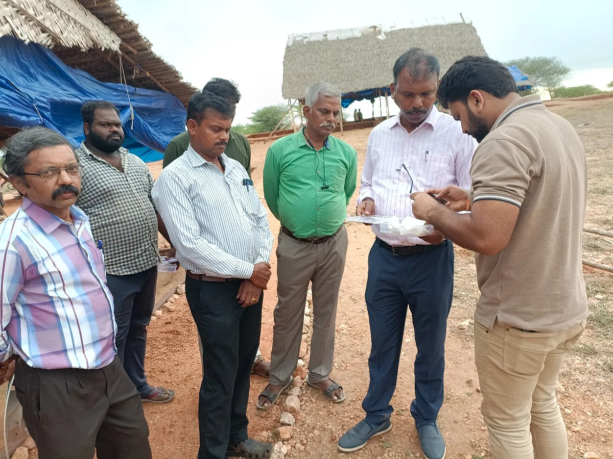 தங்கக் காதணியை ஆய்வு செய்யும் தொல்லியல் அதிகாரிகள்