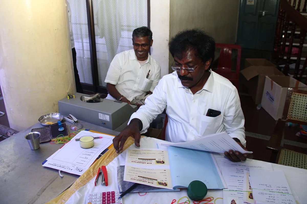பணம் எண்ணும் எந்திரத்துடன் ஊழியர்கள்