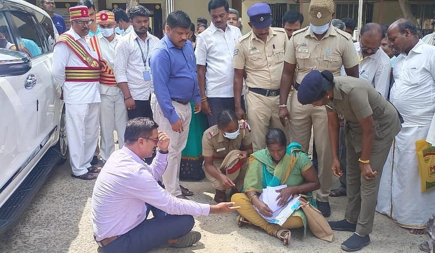 தரையில் அமர்ந்திருக்கும் மாவட்ட ஆட்சியர்