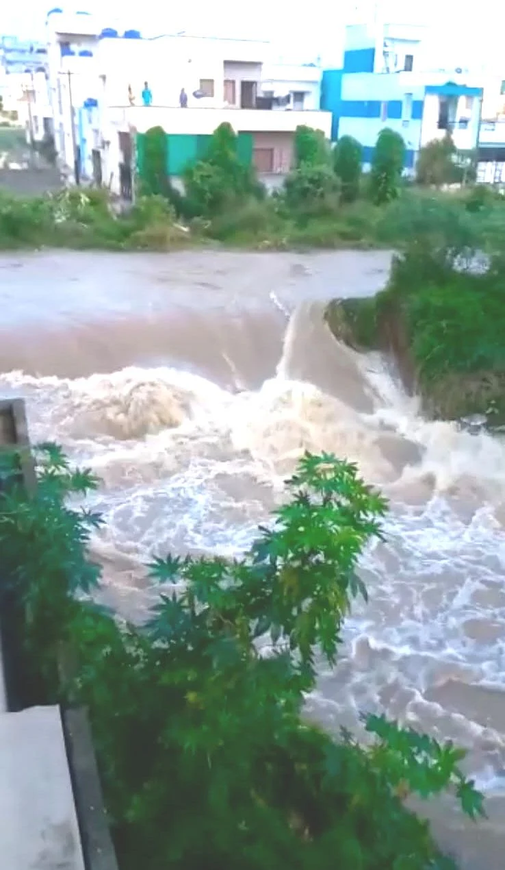 வீடுகளுக்கு நடுவே பாயும் வெள்ளநீர்