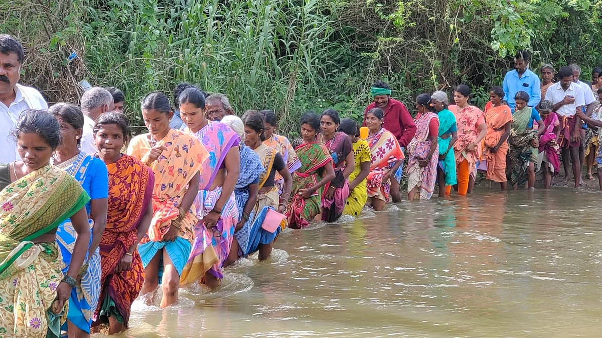 சடலத்தை அடக்கம் செய்ய, இடுப்பளவு நீரில் நடந்து செல்லும் மக்கள்.