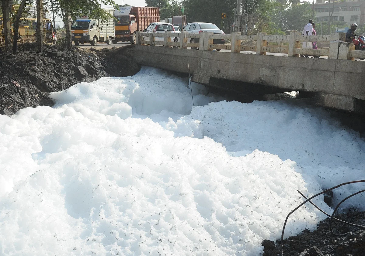 கழிவுநீரால் நுரையுடன் செல்லும் ஏரி நீர்.