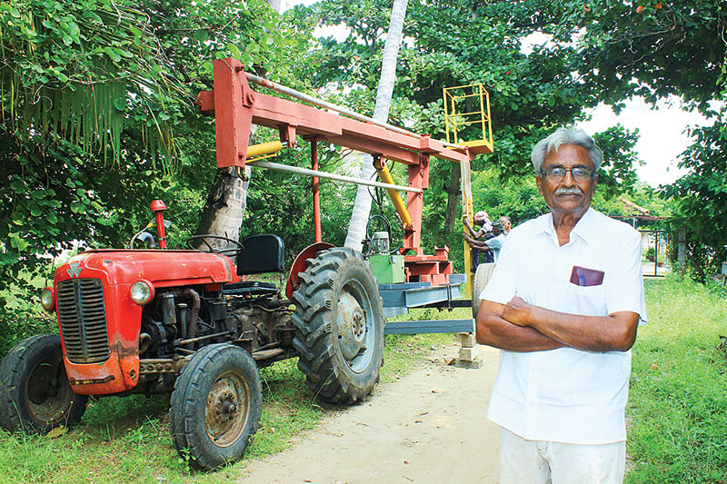 தென்னை மரம் ஏறும் கருவியுடன்