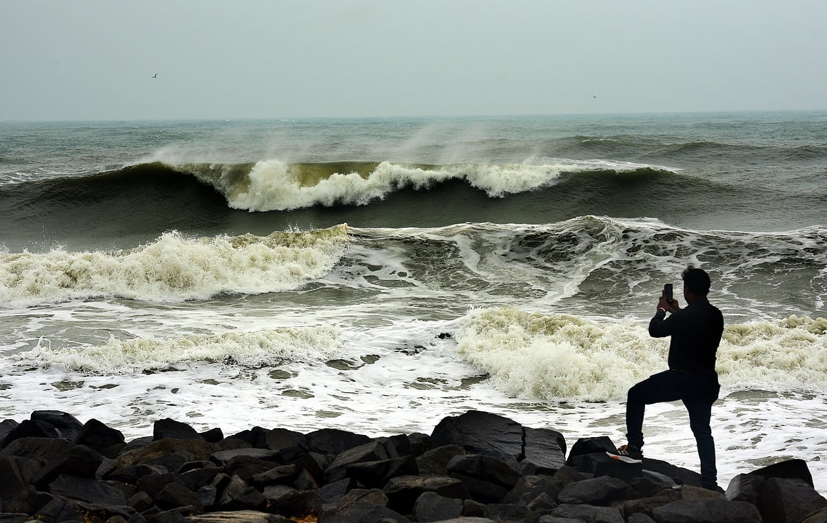 அலையில் சீற்றத்தை புகைப்படம் எடுக்கும் வாலிபர்